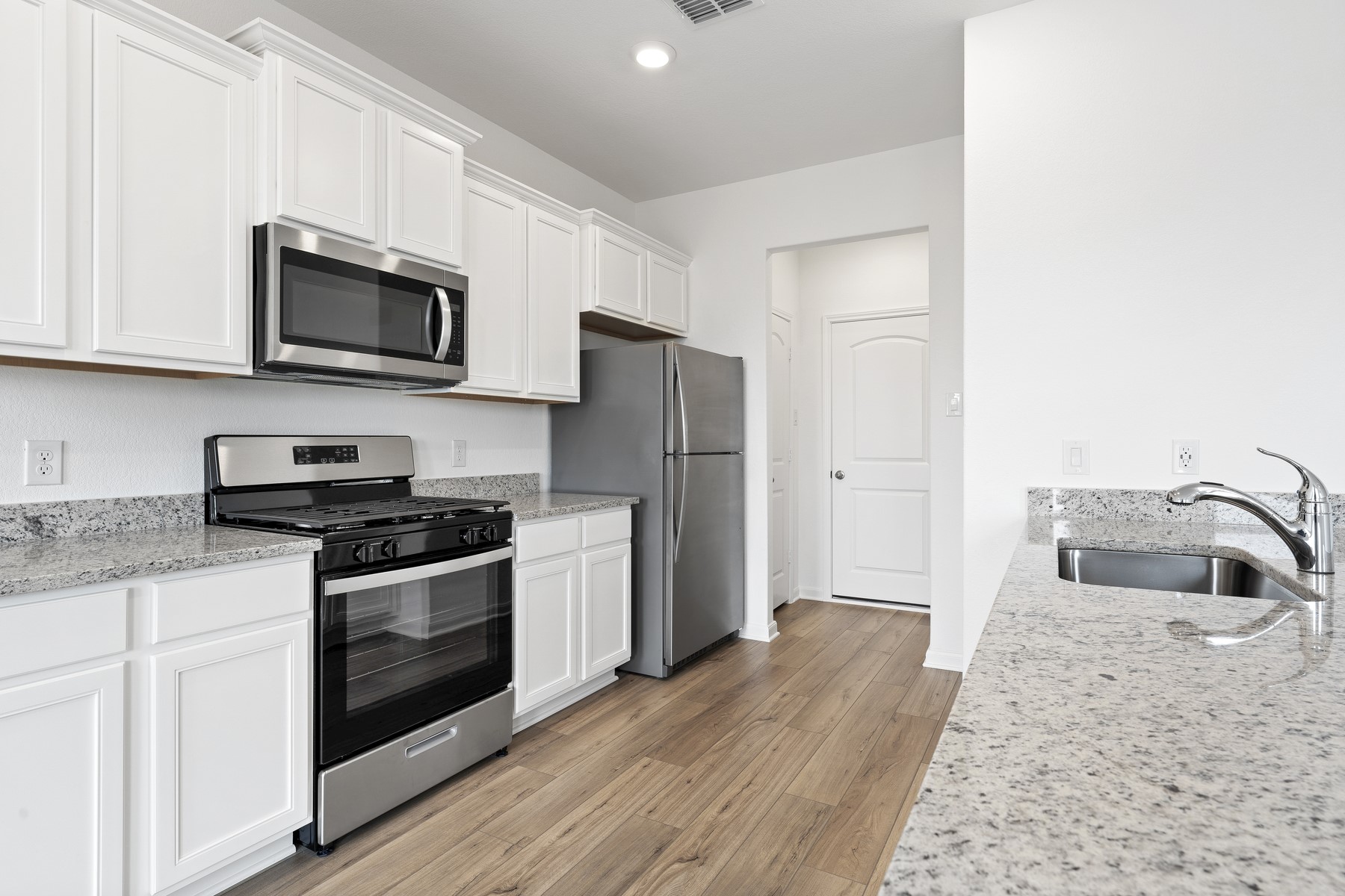 448 Aplite Pass Maxwell, TX 78656 - Photo 4 of 11 a kitchen with stainless steel appliances granite countertop a stove a microwave and a refrigerator