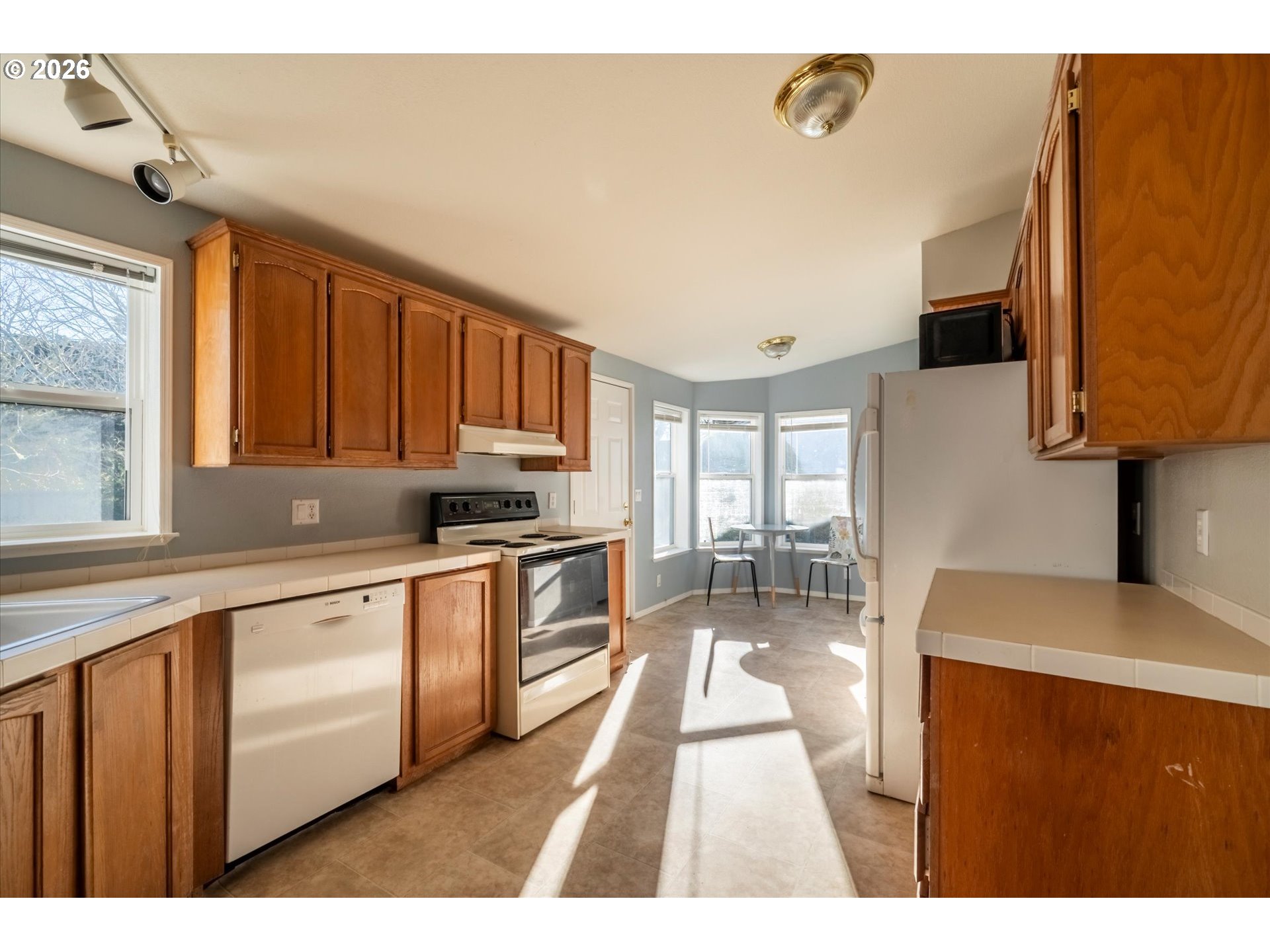 887 Jackson Avenue Southwest Bandon, OR 97411 - Photo 16 of 29 a kitchen with stainless steel appliances granite countertop a stove a sink dishwasher and a microwave oven with wooden cabinets