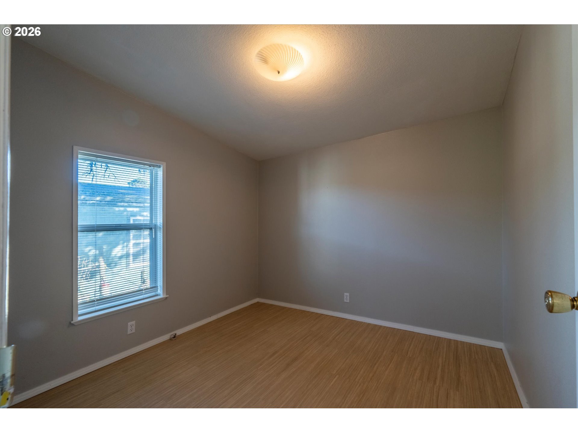 887 Jackson Avenue Southwest Bandon, OR 97411 - Photo 23 of 29 a view of an empty room with wooden floor and windows