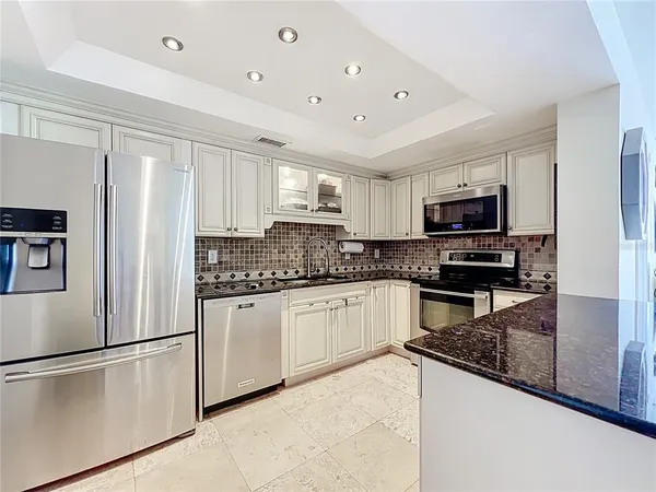 a kitchen with stainless steel appliances granite countertop a refrigerator stove microwave and sink