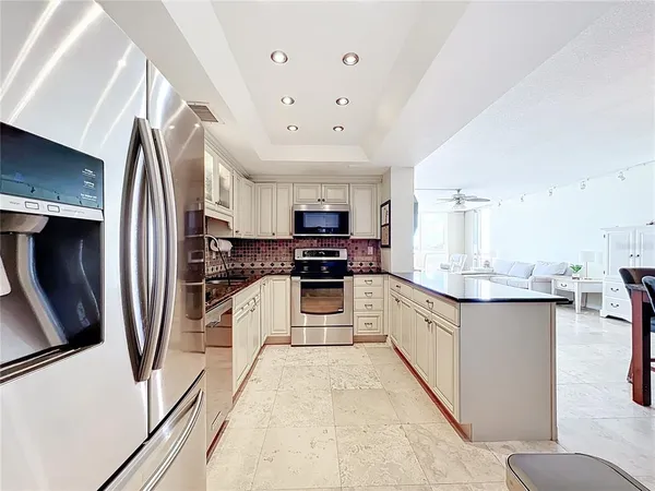 a large kitchen with stainless steel appliances and refrigerator