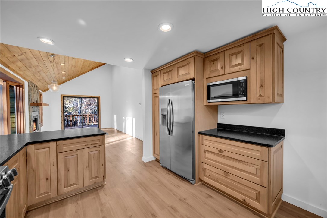 208 Meadow Loop Newland, NC 28657 - Photo 5 of 46 a kitchen with stainless steel appliances granite countertop a refrigerator a stove top oven a sink and dishwasher with wooden floor