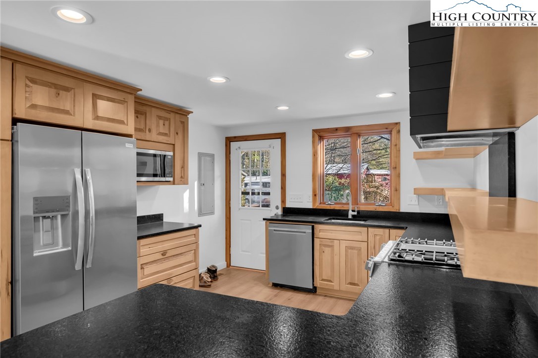 208 Meadow Loop Newland, NC 28657 - Photo 7 of 46 a kitchen with stainless steel appliances granite countertop a refrigerator and a stove top oven with wooden floor