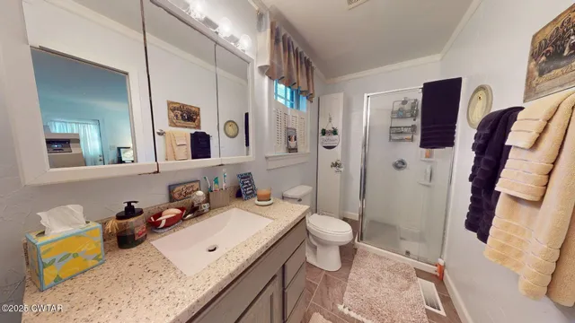 a bathroom with a granite countertop sink mirror vanity and toilet