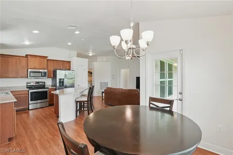 a view of a dining room with furniture a chandelier and wooden floor