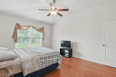 a bedroom with a bed a chandelier and a window