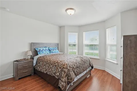 a bedroom with a bed and a large window