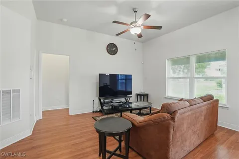 a living room with furniture a flat screen tv and a window