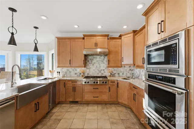 a large kitchen with granite countertop lots of white furniture and stainless steel appliances