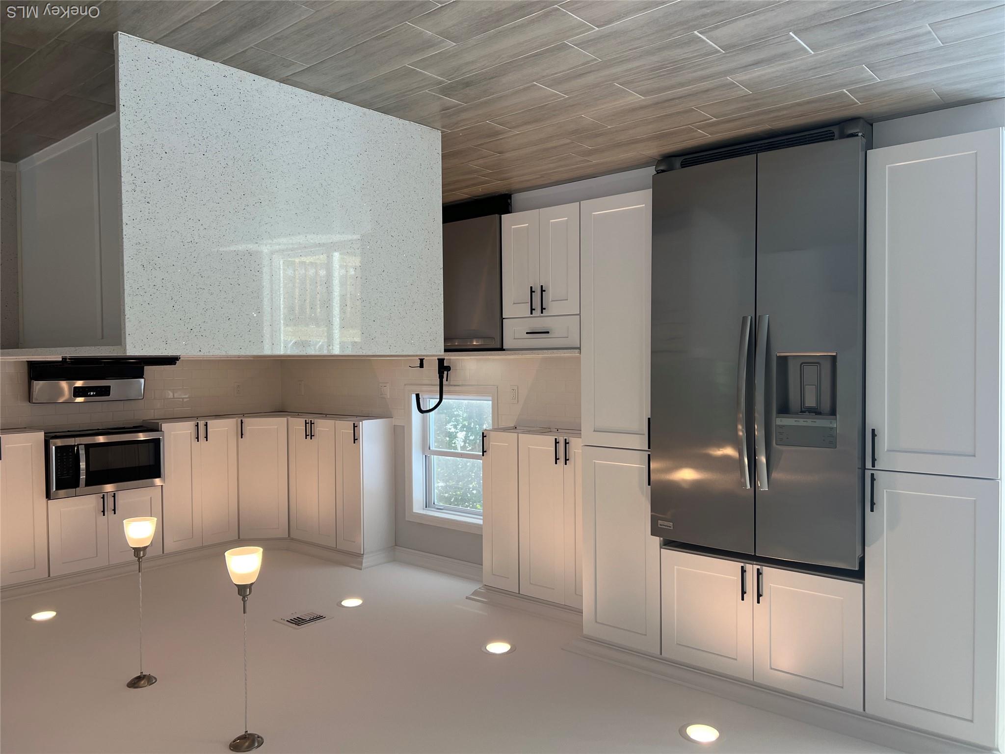 35 Babylon Road Mastic Beach, NY 11951 - Photo 7 of 19 a kitchen with kitchen island granite countertop wooden cabinets and a stainless steel appliances
