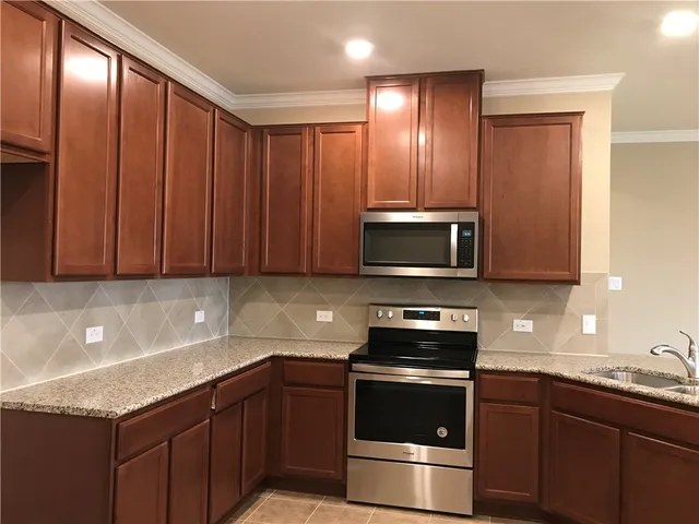 a kitchen with granite countertop stainless steel appliances and wooden cabinets