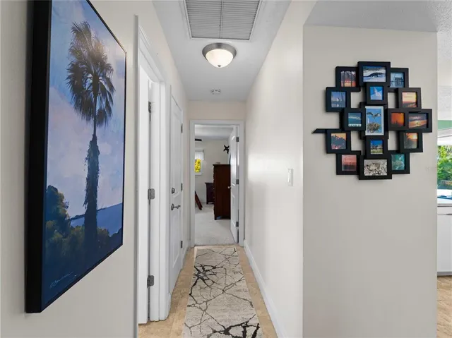 a kitchen with stainless steel appliances a sink a stove a refrigerator cabinets and chairs