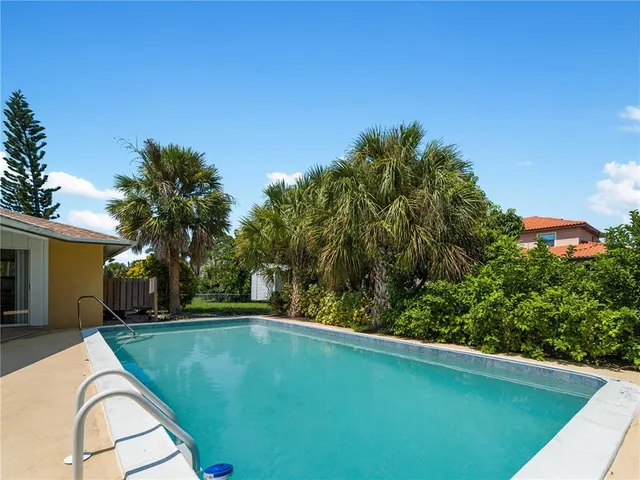 a dining room with furniture large windows and a chandelier