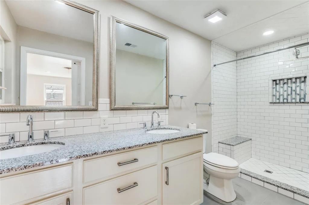 529 Roberts Cut Off Road River Oaks, TX 76114 - Photo 6 of 12 Bathroom featuring double vanity, a stall shower, and decorative backsplash