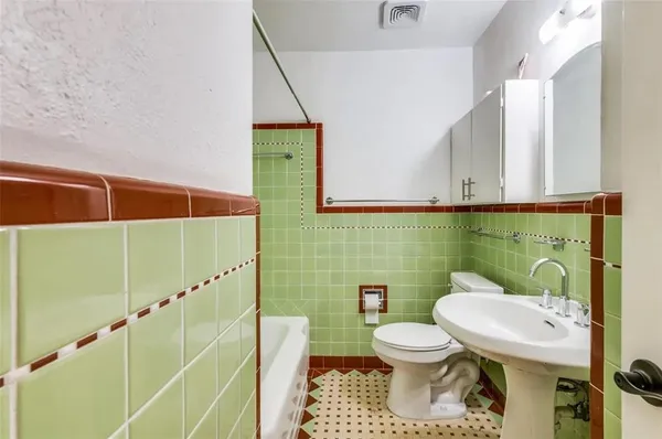 a bathroom with a toilet sink and mirror