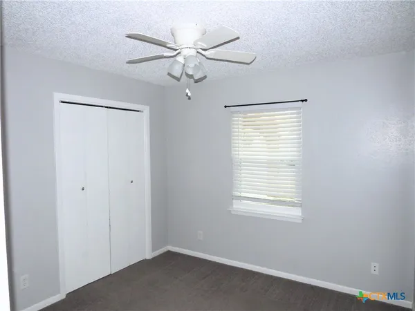 a view of a room with a window and a ceiling fan