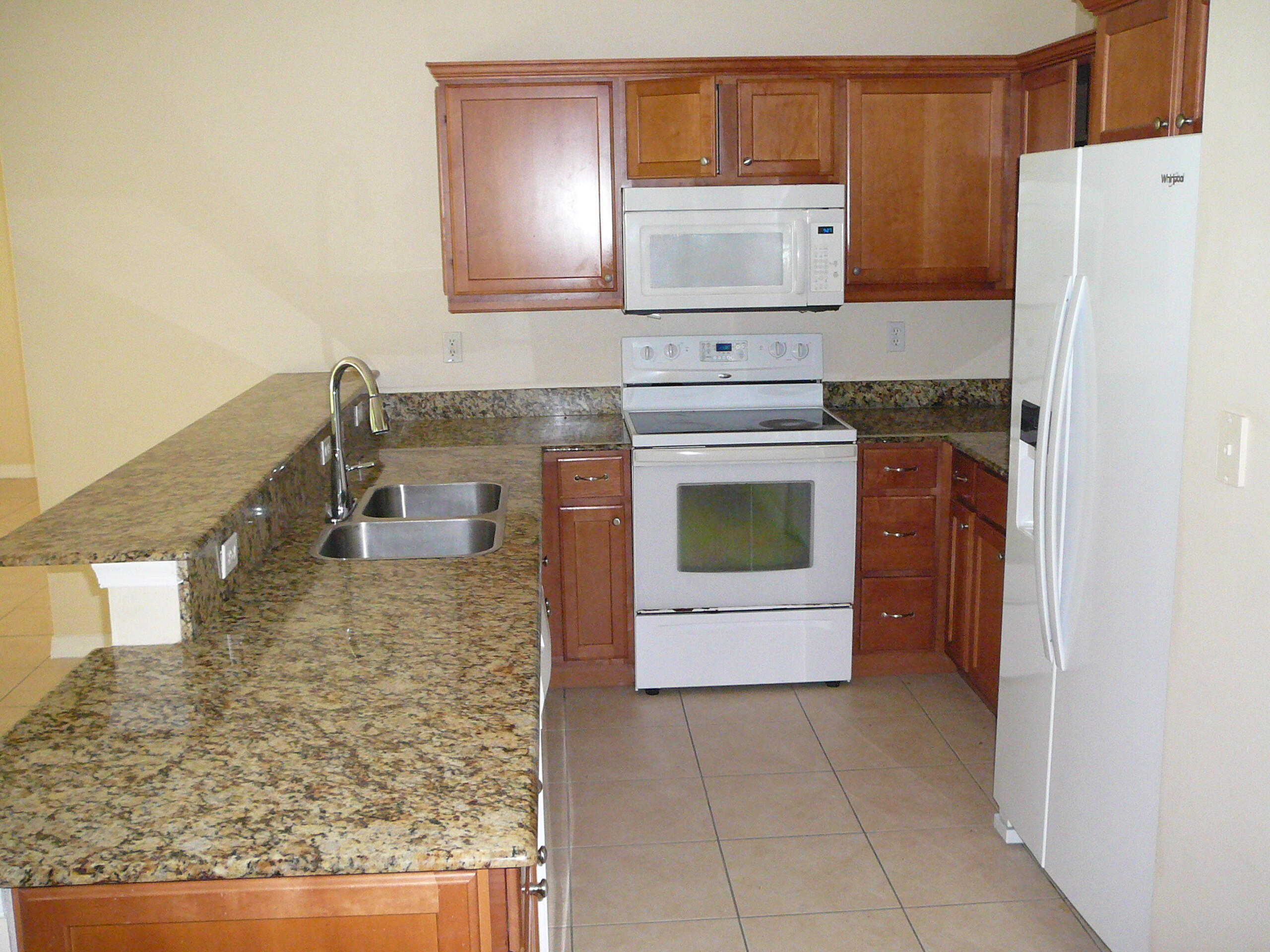 6512 Las Palmas Way Port St. Lucie, FL 34952 - Photo 24 of 45 a kitchen with a stove and a refrigerator