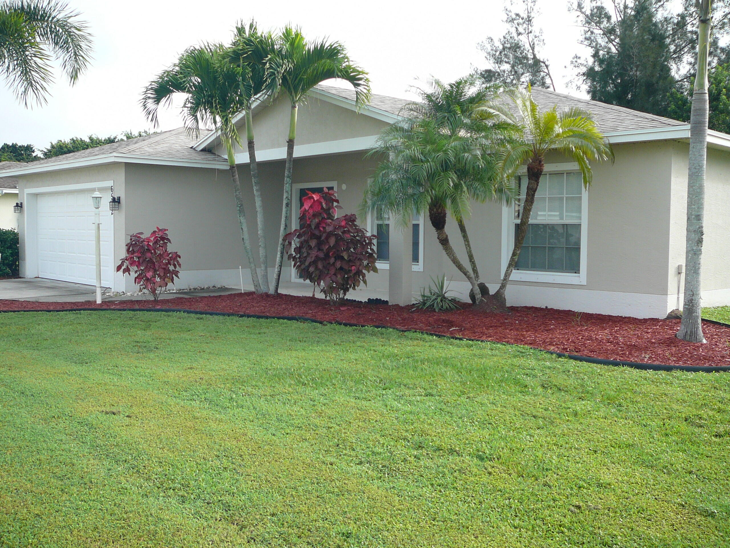 6512 Las Palmas Way Port St. Lucie, FL 34952 - Photo 3 of 45 a front view of a house with garden