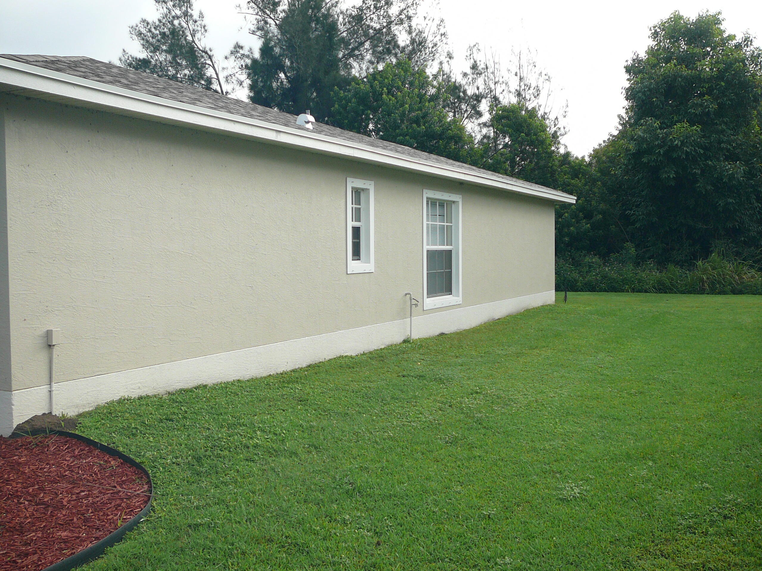 6512 Las Palmas Way Port St. Lucie, FL 34952 - Photo 8 of 45 a backyard of a house with lots of green space
