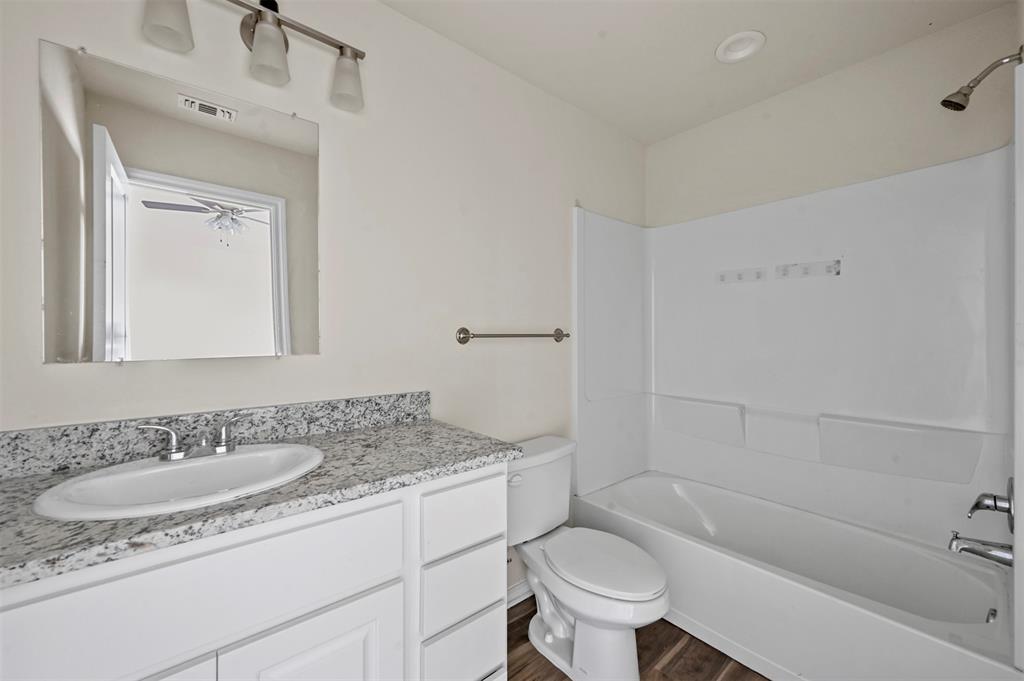 601 Thomas Street, Unit 1 Bonham, TX 75418 - Photo 15 of 23 a bathroom with a granite countertop sink toilet and shower