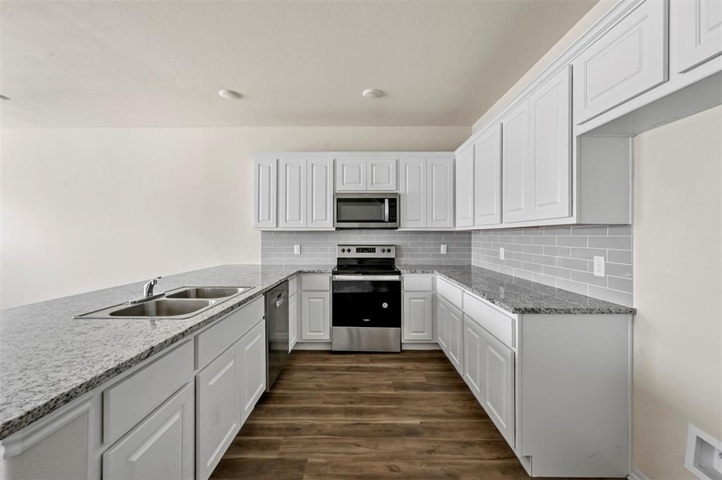 601 Thomas Street, Unit 1 Bonham, TX 75418 - Photo 5 of 23 a kitchen with granite countertop a sink and stainless steel appliances