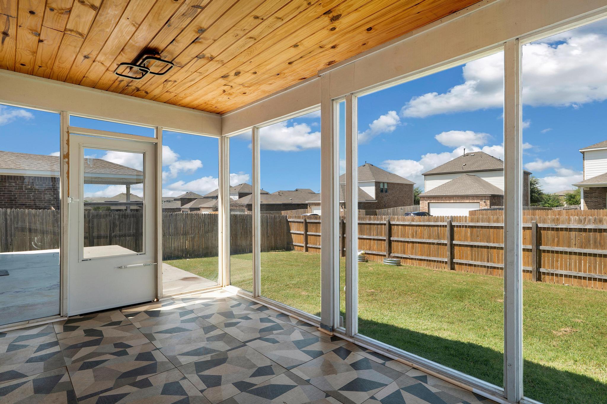 1341 Eagle Ray Street Leander, TX 78641 - Photo 33 of 37 A well-lit sunroom provides serene views of the green backyard, enclosed by a privacy fence.