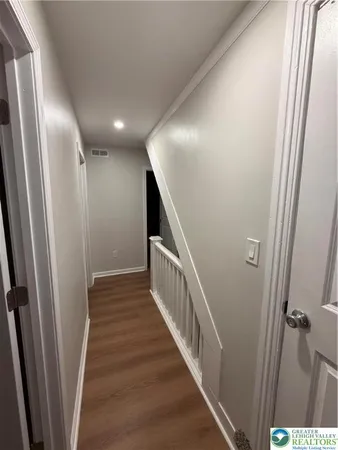a view of a hallway with wooden floor