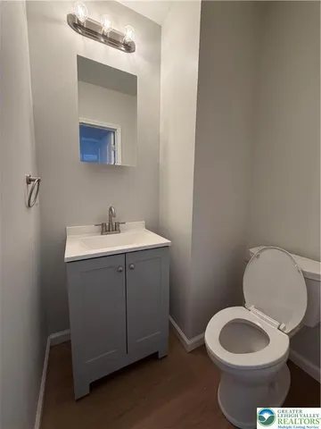 a bathroom with a toilet sink vanity and mirror