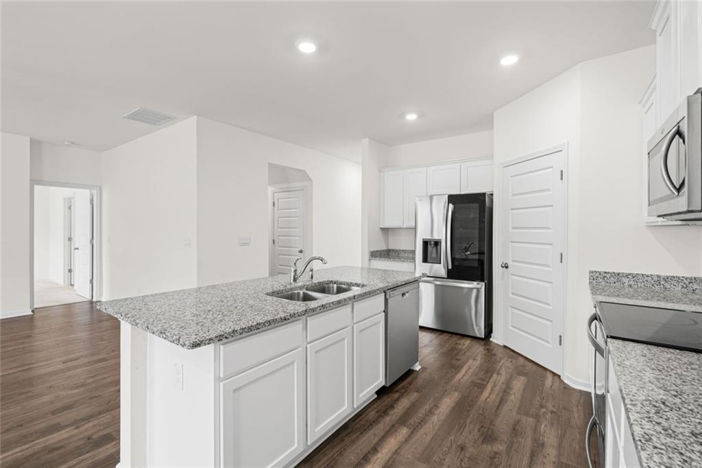 166 Champlain Road Hoschton, GA 30548 - Photo 12 of 53 a kitchen with a sink stove and refrigerator
