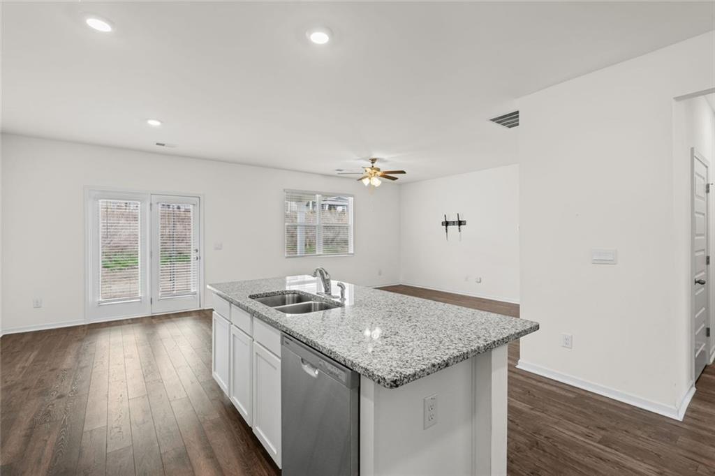 166 Champlain Road Hoschton, GA 30548 - Photo 13 of 53 a kitchen with granite countertop kitchen island wooden floors and center island