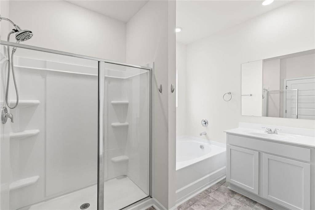 166 Champlain Road Hoschton, GA 30548 - Photo 22 of 53 a bathroom with a bathtub shower sink vanity and a mirror