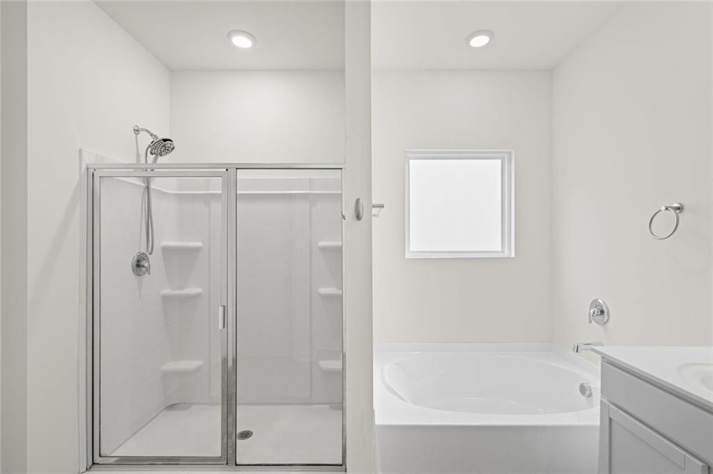 166 Champlain Road Hoschton, GA 30548 - Photo 23 of 53 a bathroom with a bathtub and a shower