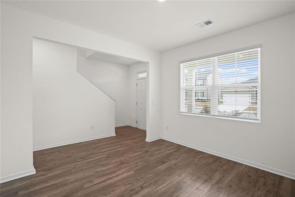166 Champlain Road Hoschton, GA 30548 - Photo 5 of 53 an empty room with wooden floor and windows