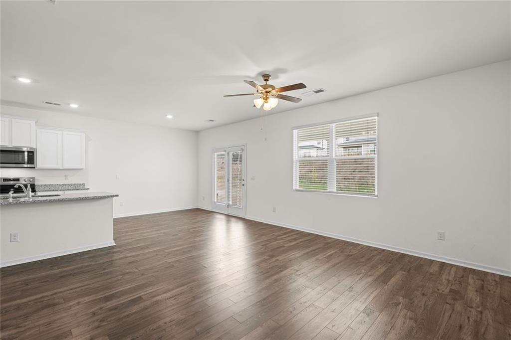 166 Champlain Road Hoschton, GA 30548 - Photo 7 of 53 a view of an empty room with window and wooden floor