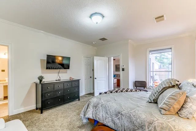 a bedroom with a bed and a flat screen tv