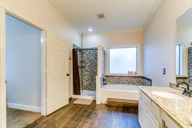 a spacious bathroom with a granite countertop tub sink and mirror