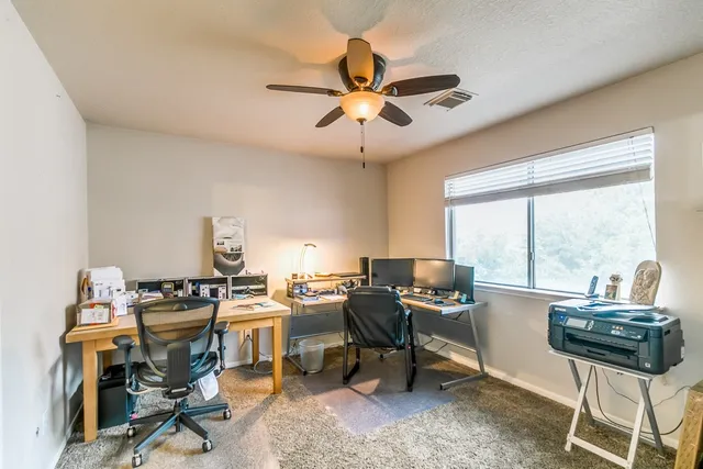 a view of a workspace with furniture and a window