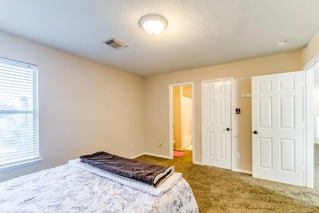 a bedroom with a bed and a window