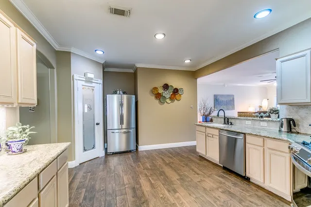 a kitchen with stainless steel appliances granite countertop a refrigerator and a sink