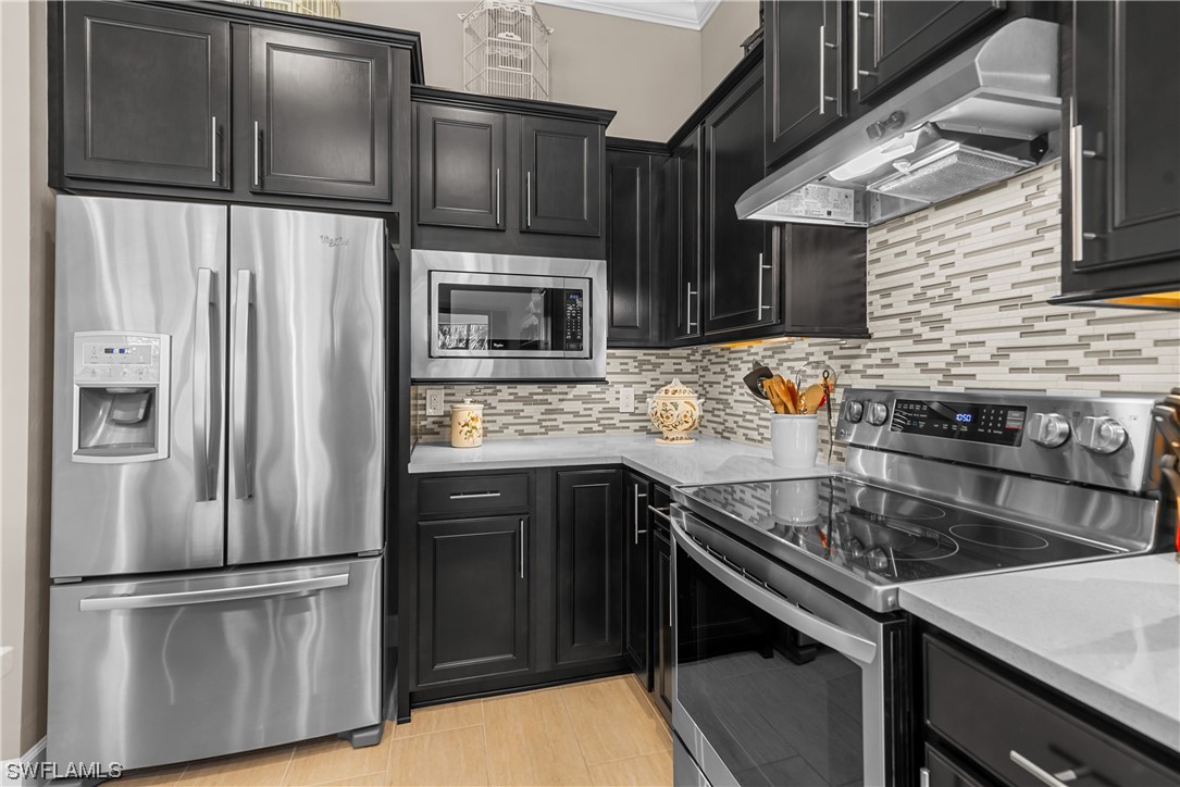 20198 Corkscrew Shores Boulevard Estero, FL 33928 - Photo 20 of 50 a kitchen with stainless steel appliances and wooden cabinets