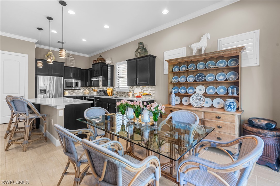 20198 Corkscrew Shores Boulevard Estero, FL 33928 - Photo 23 of 50 a dining room with furniture a chandelier and kitchen view