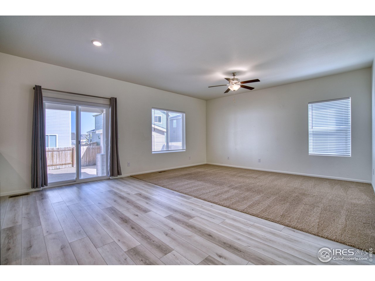 7015 Fall River Drive Frederick, CO 80530 - Photo 13 of 34 a view of an empty room with a window and wooden floor