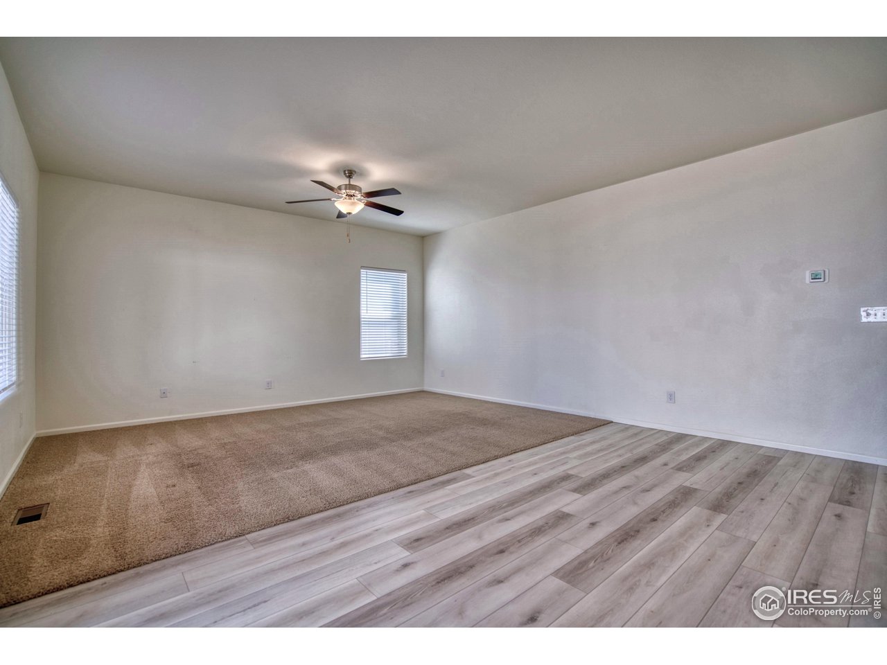 7015 Fall River Drive Frederick, CO 80530 - Photo 14 of 34 a view of an empty room with a ceiling fan and window