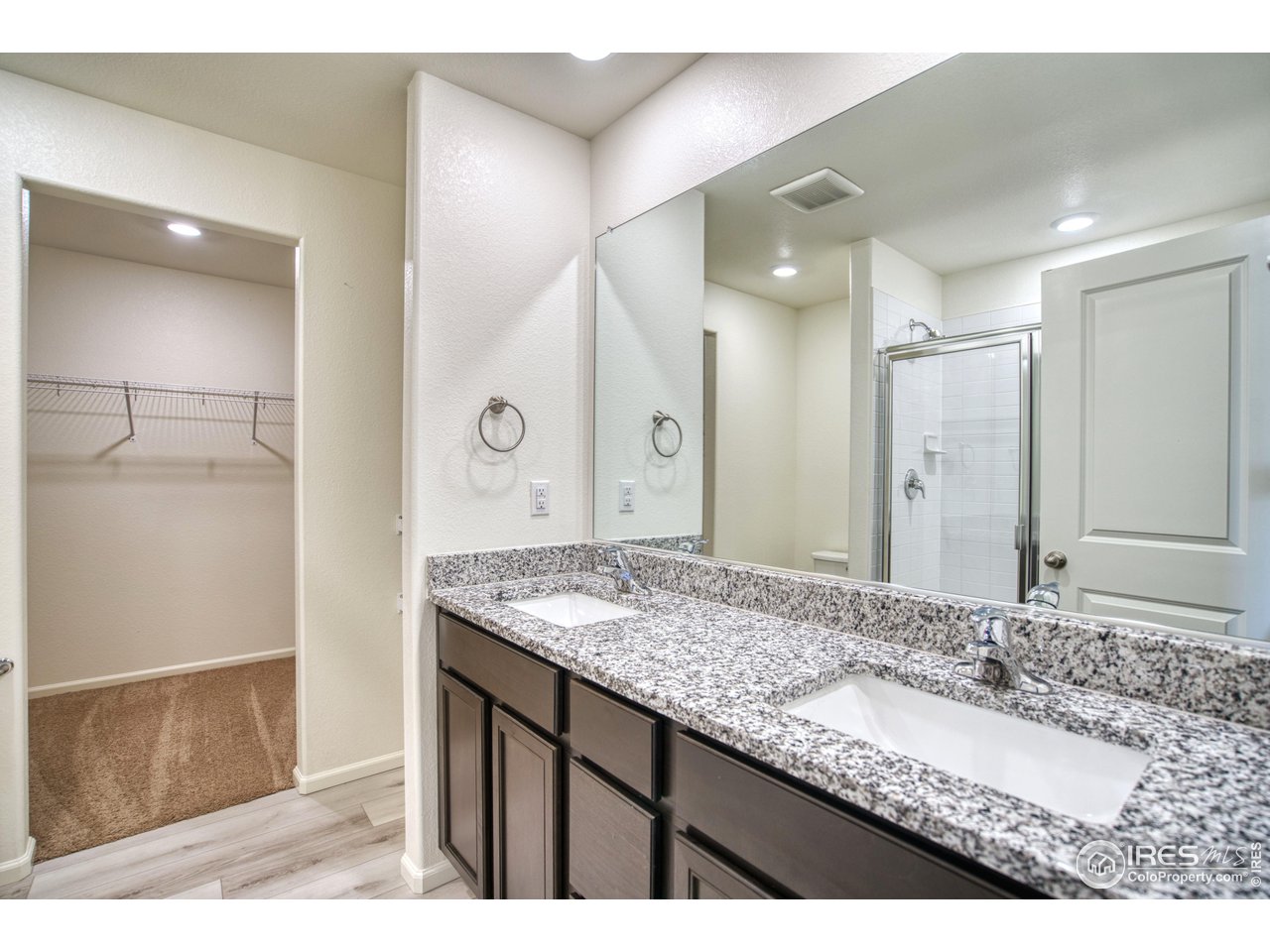 7015 Fall River Drive Frederick, CO 80530 - Photo 18 of 34 a bathroom with a granite countertop sink and a mirror
