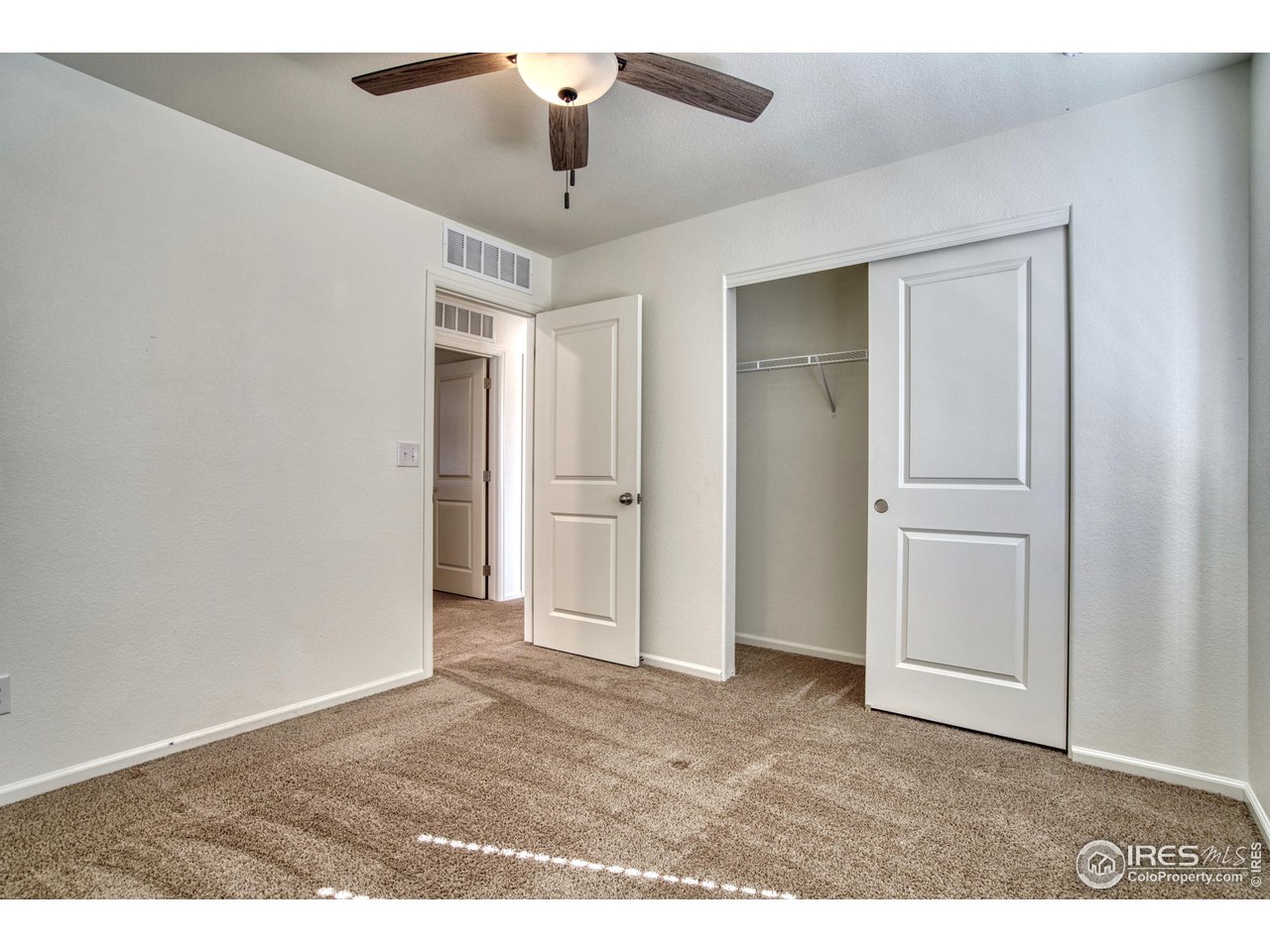 7015 Fall River Drive Frederick, CO 80530 - Photo 21 of 34 an empty room with closet and a ceiling fan