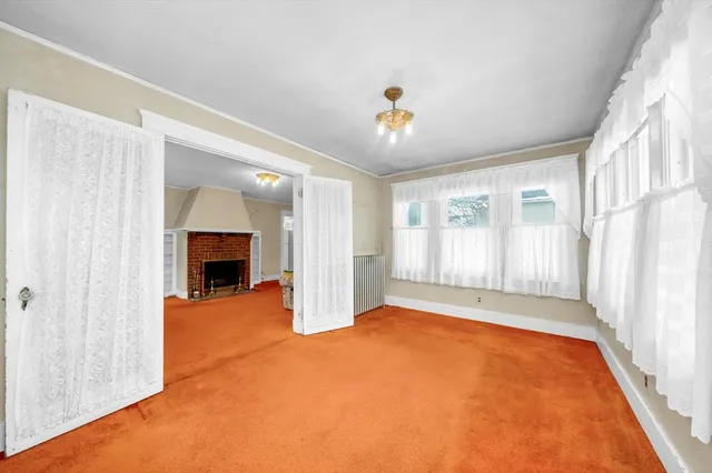 a view of an empty room with a fireplace and a window