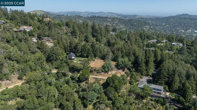 an aerial view of residential house with outdoor space and trees all around