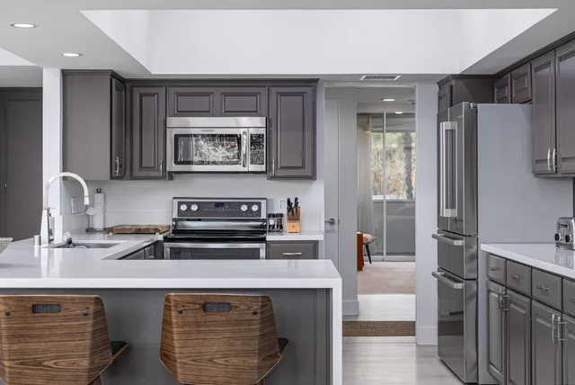 a kitchen with stainless steel appliances a stove a refrigerator and a sink