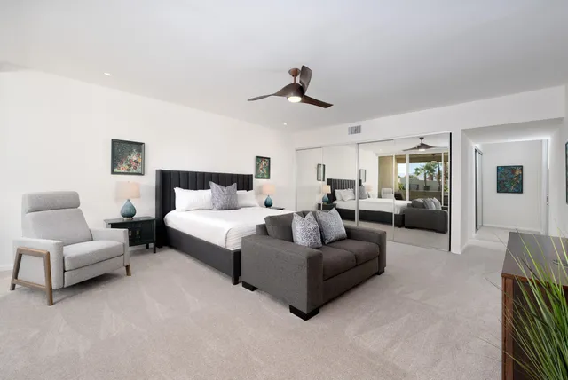 a spacious bedroom with a bed couch and window