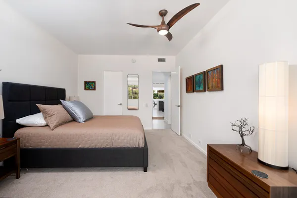 a bedroom with a bed a couch and a flat tv screen